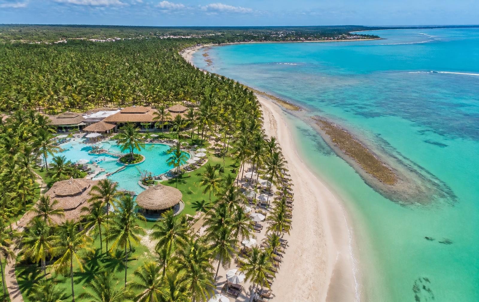 Vista aérea do resort entre coqueiros e piscinas naturais